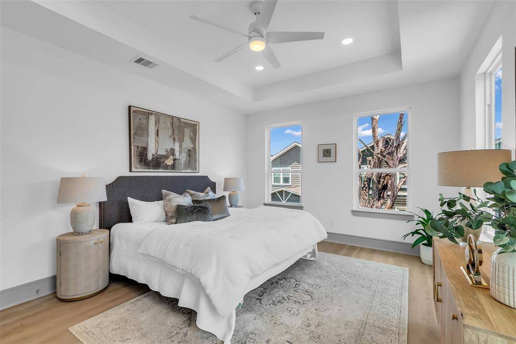 Welcome to the primary bedroom, featuring bright, airy space with large glass windows.