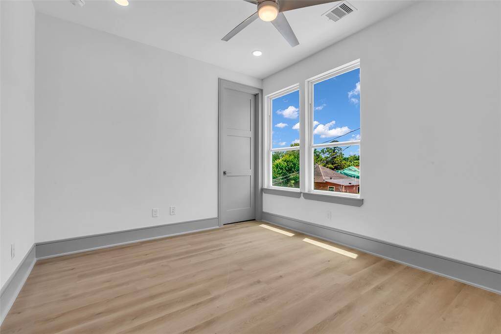 The second guest bedroom with a closed door at the corner, leading to additional storage space.