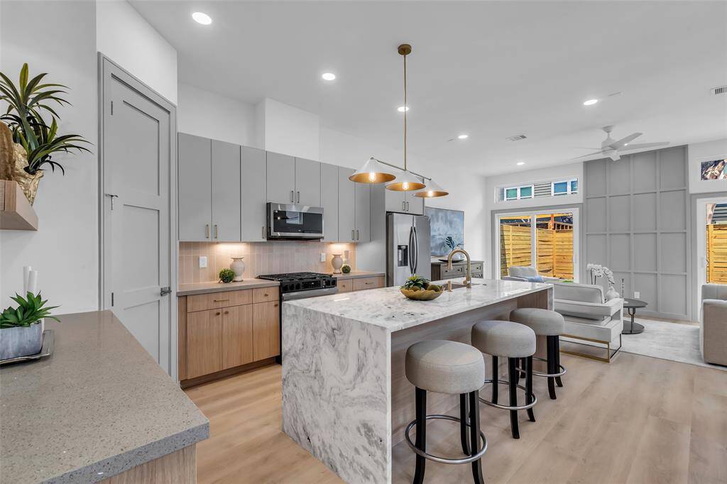 The kitchen features clean, minimalistic cabinets, with a pantry conveniently tucked behind the closed door on the left.