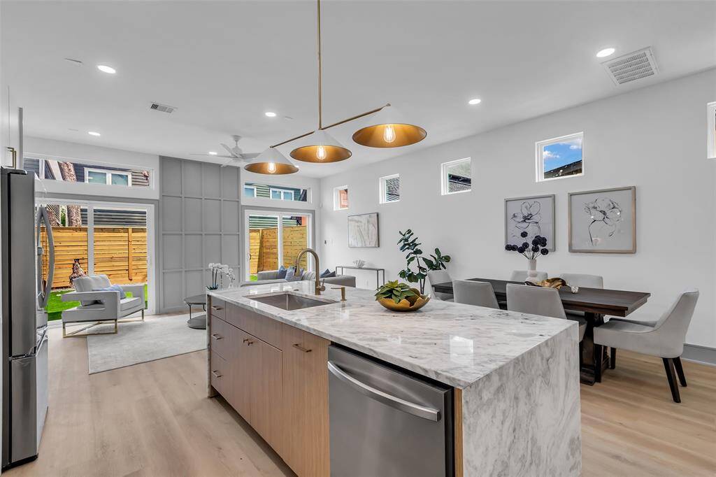 This view highlights the spacious kitchen island with a sleek, modern countertop—ideal for prep or casual meals.