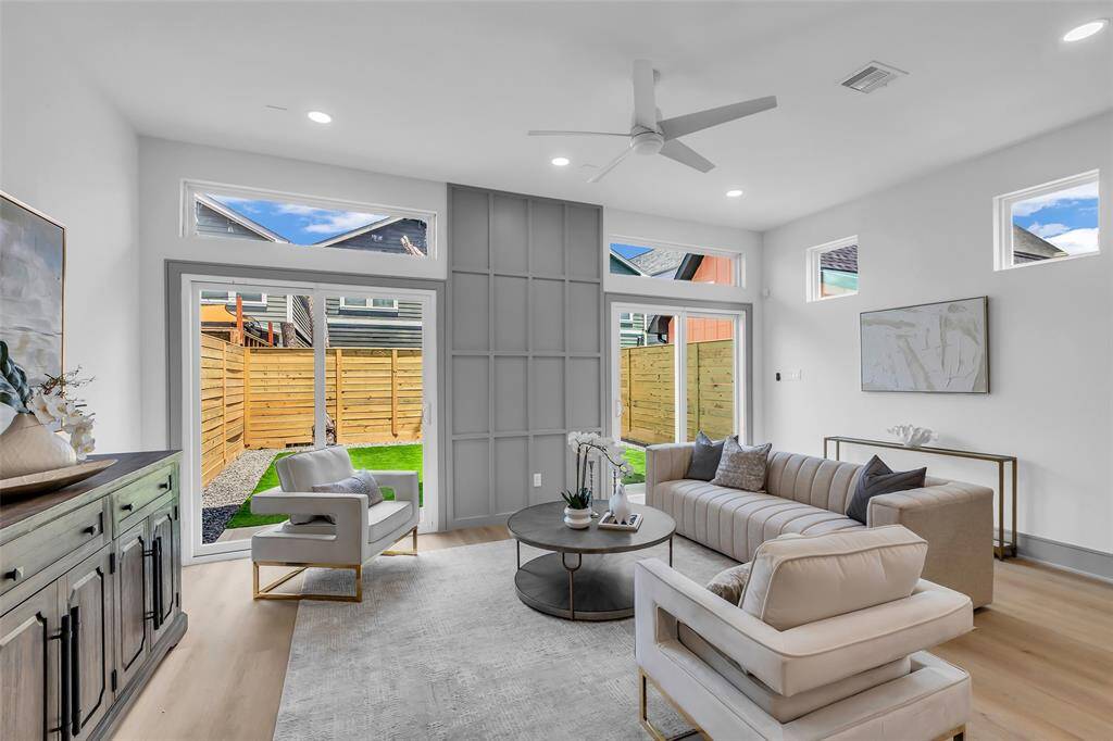 A full view of the living area featuring expansive dual glass doors that look out onto the backyard.