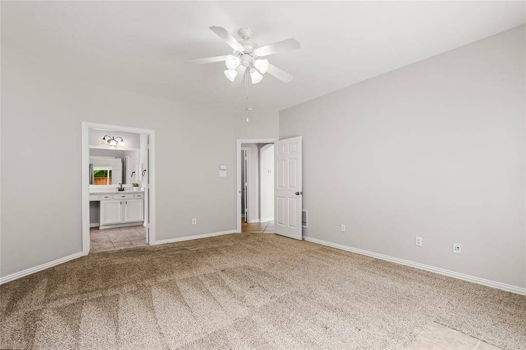 Primary bedroom with bay windows and doors leading directly to the backyard oasis