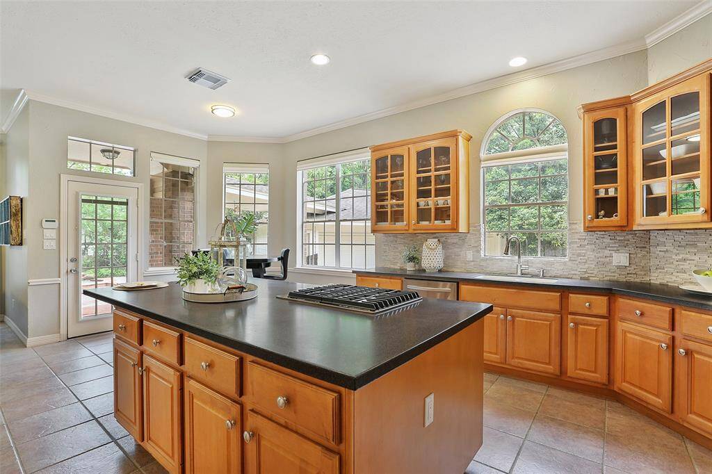 Wow! This spacious kitchen has a large center island, tons of cabinetry, and coordinates the stacked stone back splash with the two fireplaces!