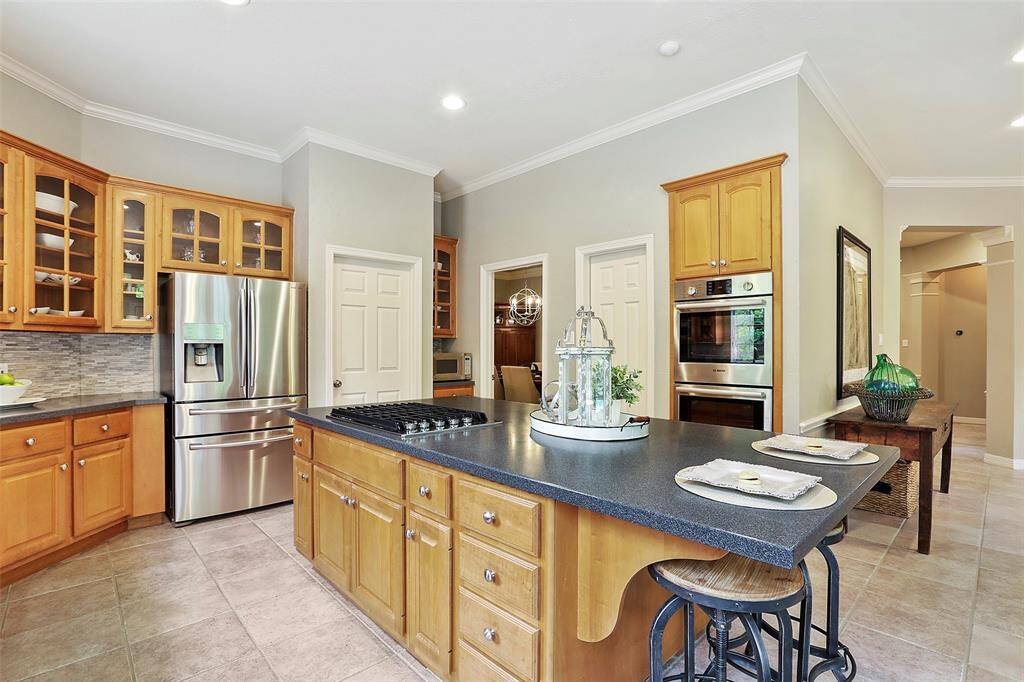 This view is back toward the dining room and the family room to the main entry hall. Notice all of the cabinetry and storage in this kitchen!