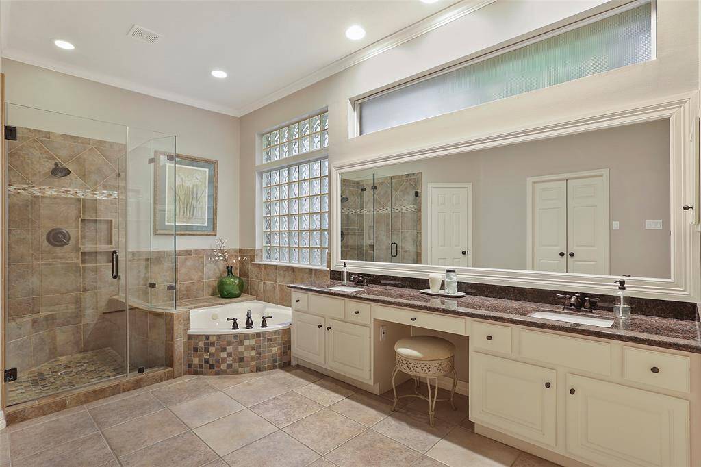The en suite primary bathroom is spacious with high ceilings and an abundance of natural light.
