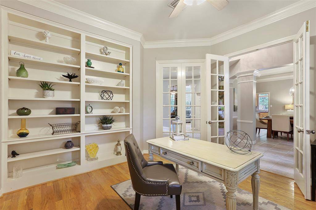This view of the office shows the built in shelves and French doors.