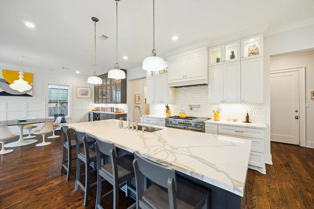 The island's striking quartz surface and pendant lighting create a natural gathering spot in this beautifully designed kitchen.