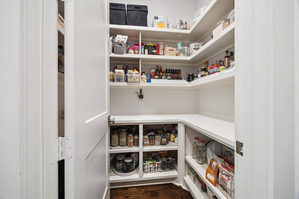 This expansive walk-in pantry offers elegant functionality, with floor-to-ceiling shelving and built-in outlets to keep appliances powered and out of sight.