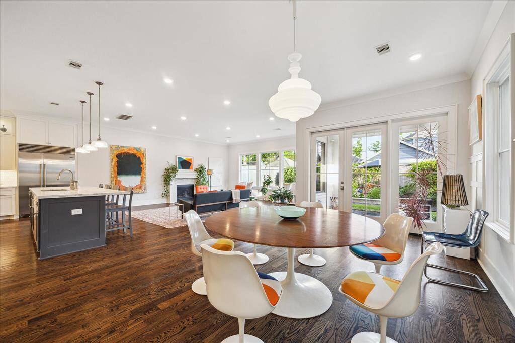 Glass doors and large windows invite in lush views, creating a seamless connection to the outdoors and elevating every day dining.