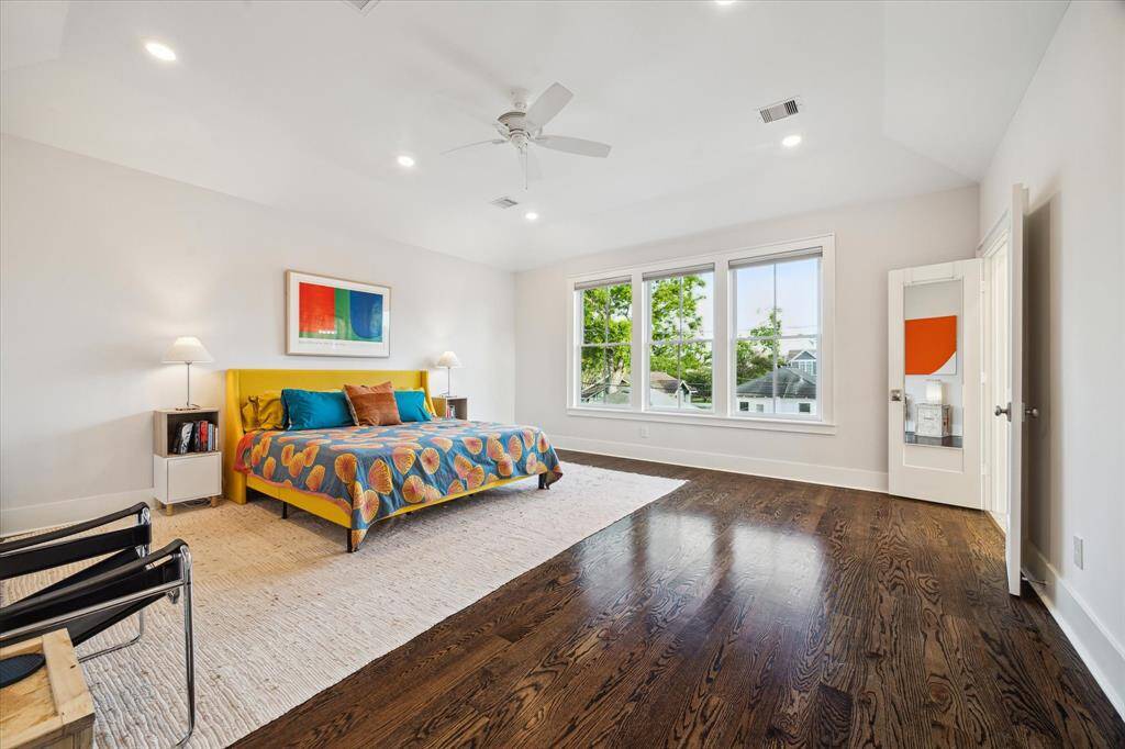 The spacious primary bedroom overlooks the expansive backyard and features custom cellular shades for tailored light control