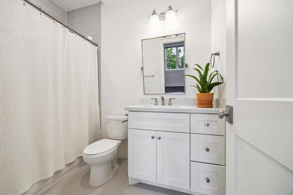 2nd en-suite bathroom blends clean design with classic comfort and features a full tub with a shower