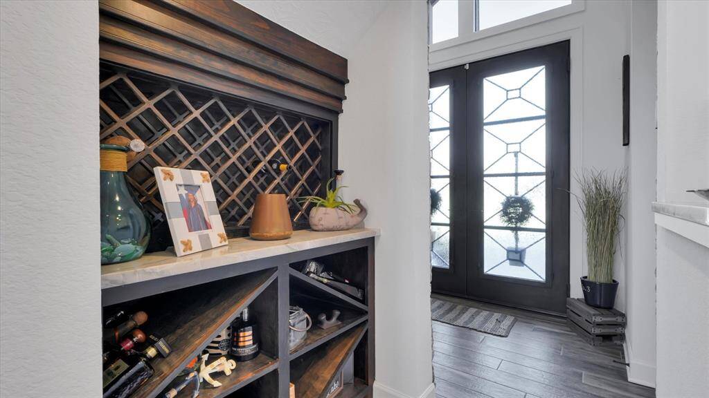 This home has several special built in features, including this wood wine rack with a granite counter, located in the hall under the staircase and just off the wet bar.