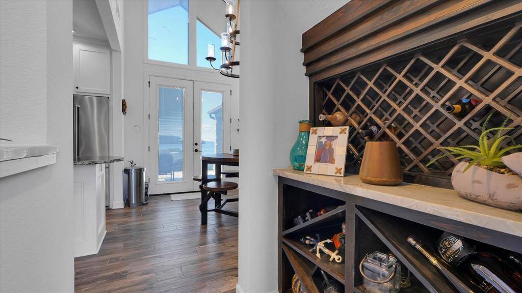 The staircase is located in the center of the main living area and every side of it is utilized. The built in wine storage is located at the back of the stairs, convenient to the kitchen and wet bar area.