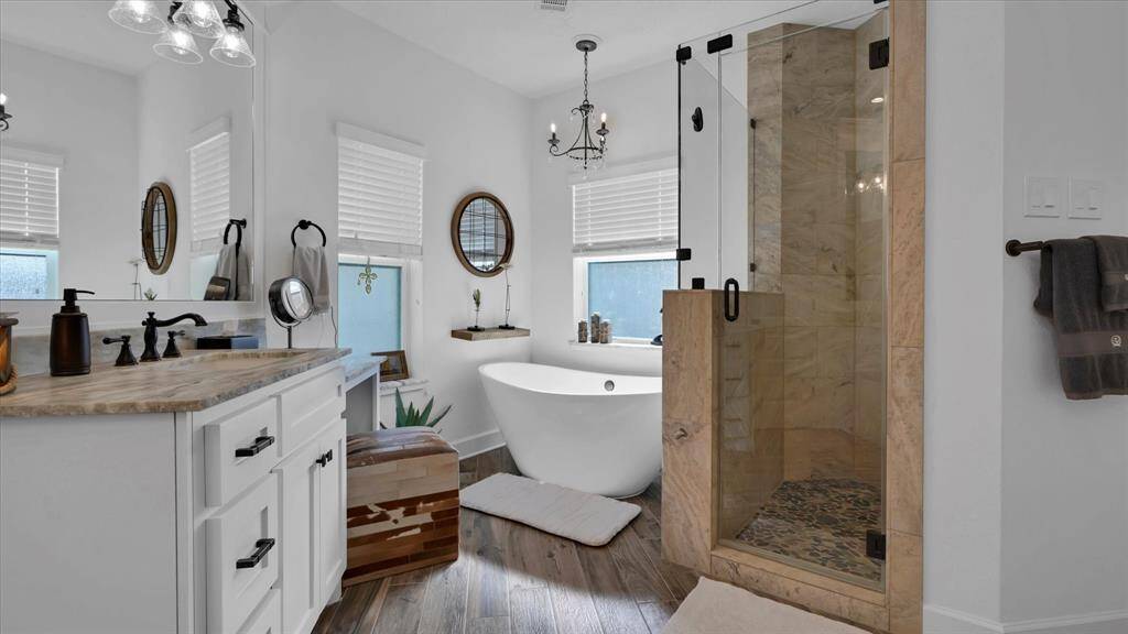 Indulge in luxury with this exquisite bathroom featuring a freestanding tub and a spacious glass-enclosed shower. Perfect for soaking in tranquility.