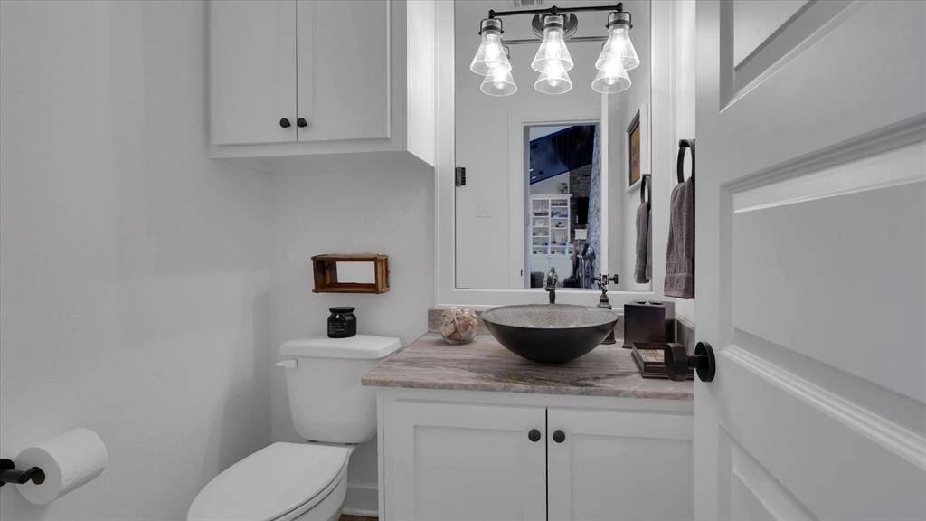 Elegantly modern powder room featuring a unique vessel sink. Conveniently located for guest.