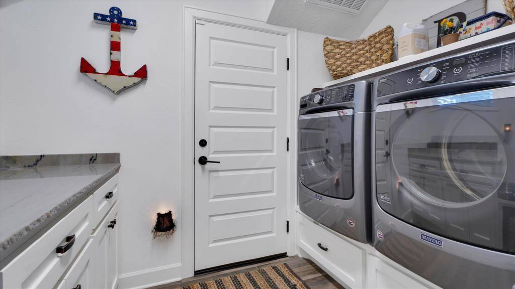 Clean laundry meets nautical charm in this stylish utility room. Equipped with top-tier appliances that are raised for ease in loading and unloading your laundry.