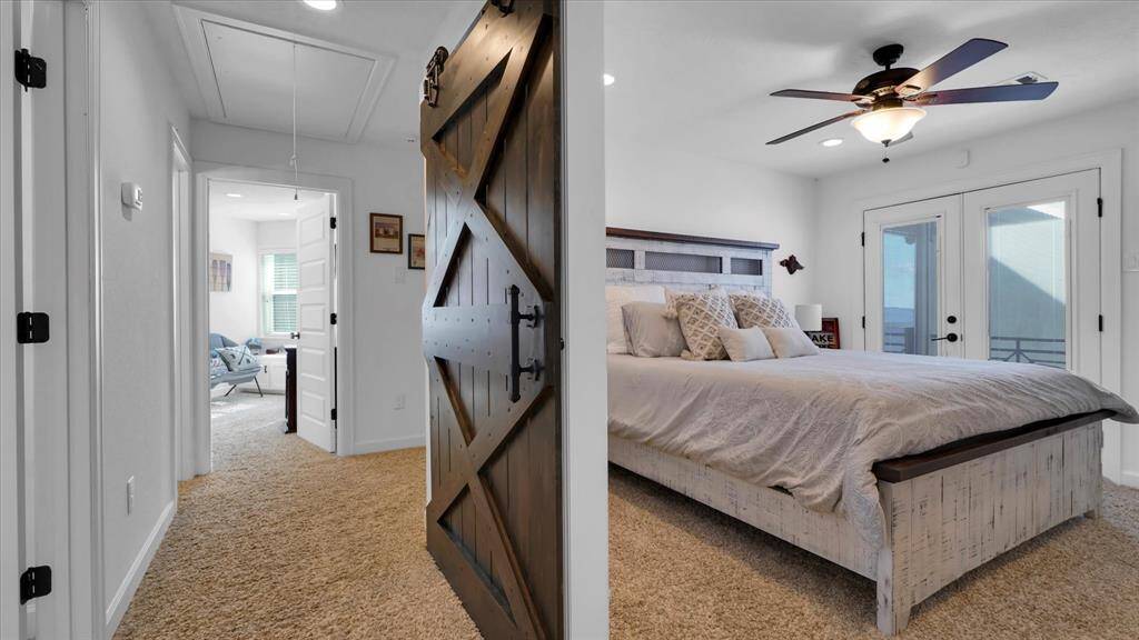 The wooden barn door adds to the rustic charm and contrast the light and bright bedroom perfectly!