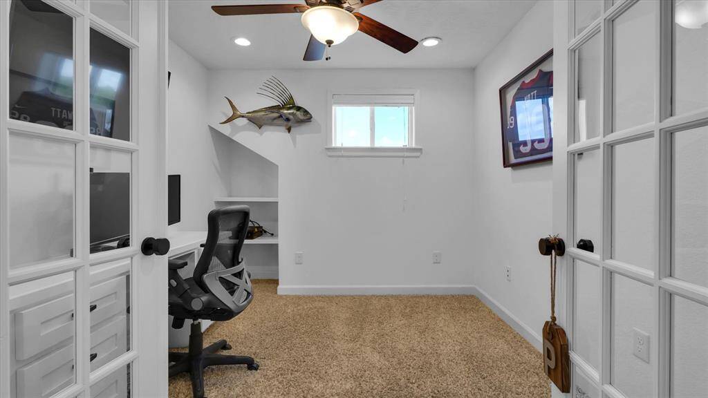 Dive into productivity in this cozy home office, featuring elegant French doors and a charming touch of the nautical. A perfect blend of functionality and flair awaits your next venture.