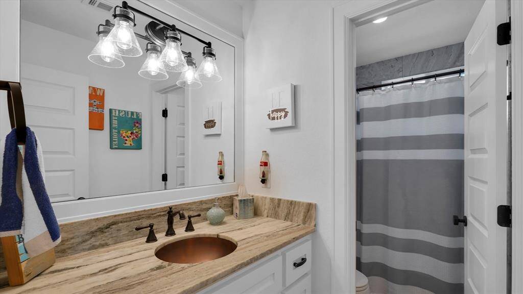 Chic bathroom design with rustic copper sink and elegant lighting. Perfect blend of style and charm!