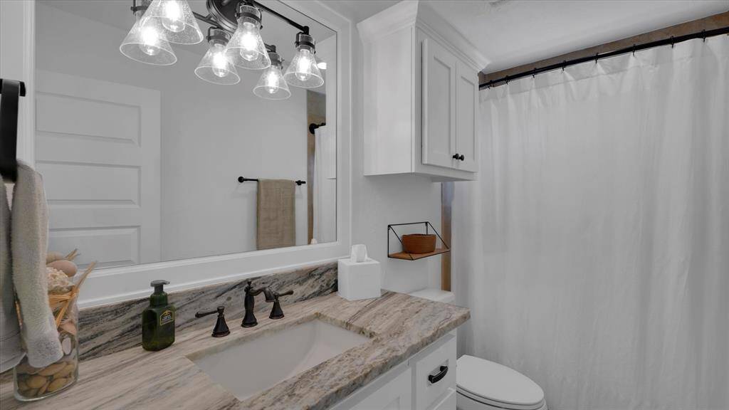 Bright bathroom with elegant granite countertop—perfect for stylish mornings and refreshing nights.