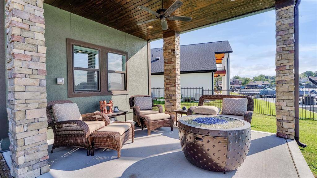 Relax on your spacious back porch with stone accents, perfect for lakeside lounging. Enjoy the warmth of the fire pit while planning your next watercraft adventure on Lake Conroe
