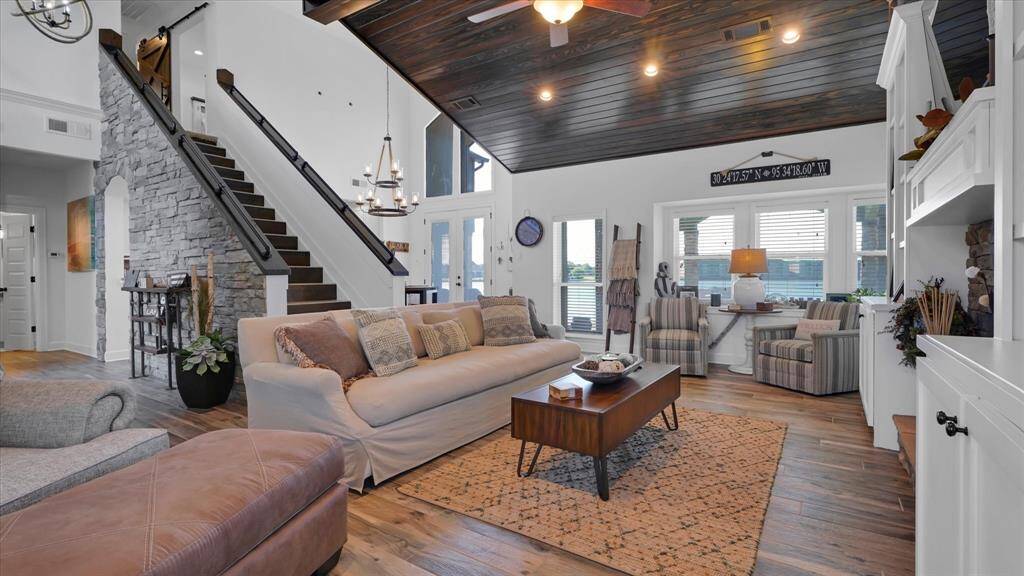The staircase located in the living area provides a heightened view of the lake making this room light and bright with contrasting rich wood accents.