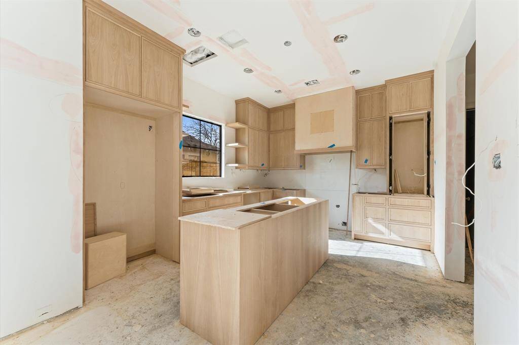 Kitchen offers custom inset white oak cabinetry and vent hood, JennAir appliances, Montreal quartz countertops and a paneled built-in refrigerator/freezer. *Photo taken in mid-March.*