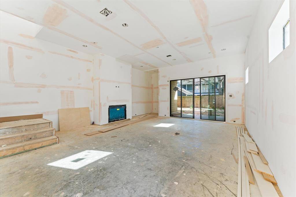 Expansive living room with modern gas fireplace and custom built dry bar for entertaining. Sliding glass door leads to the covered patio. *Photo taken in mid- March*