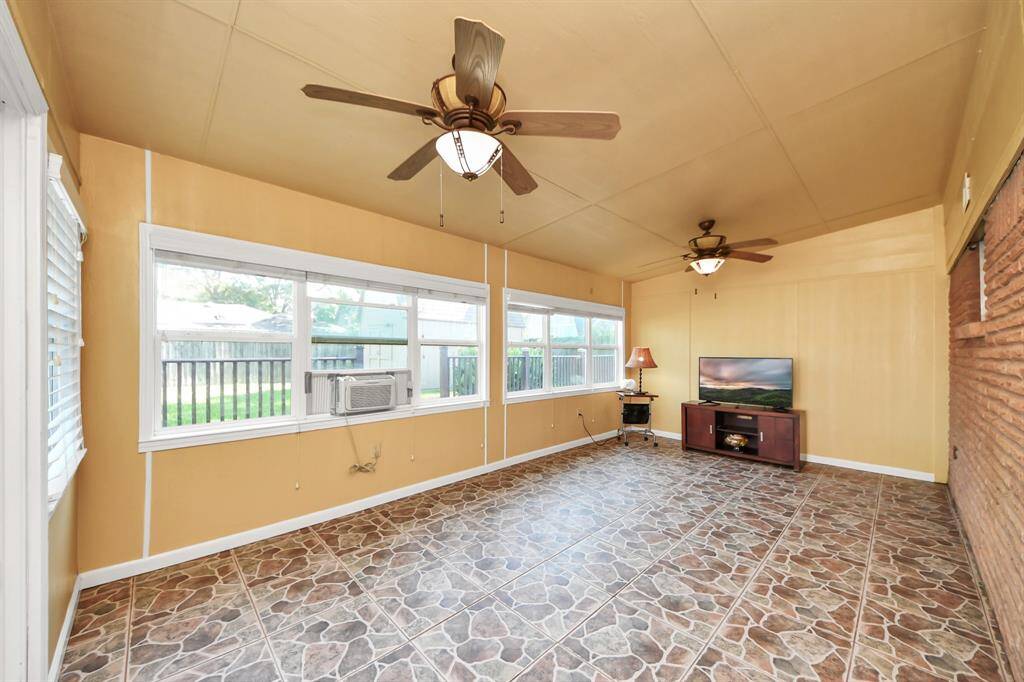 Enjoy year-round comfort in this spacious sunroom featuring large windows that fill the space with natural light. With tiled flooring, two ceiling fans, and backyard views, it’s the perfect spot to relax, entertain, or set up a playroom or home office.