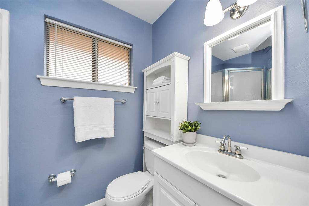Modern primary bathroom with walk-in shower and elegant finishes.