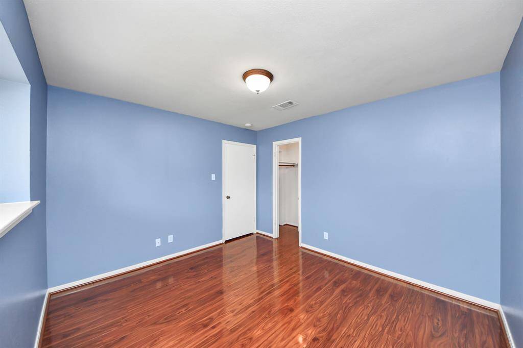 This third bedroom features the same beautiful flooring, a wide window for natural light, and a clean, neutral layout that’s perfect for a guest room, home office, or child’s room.