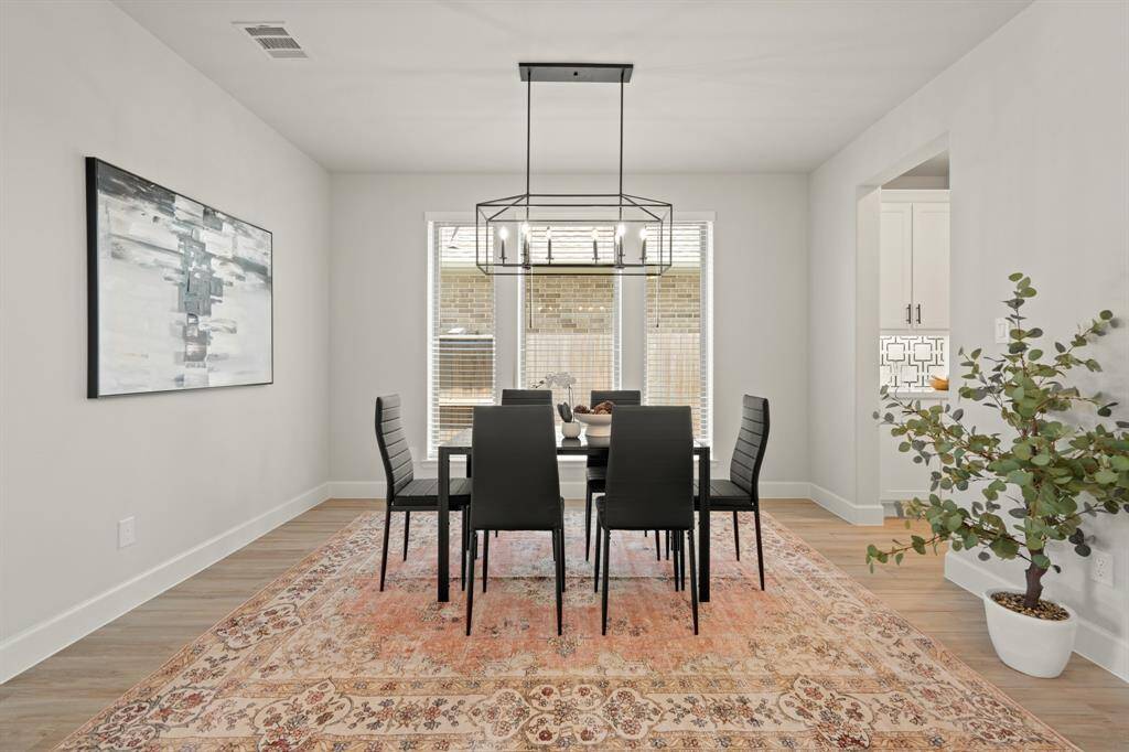 Make memories gathered around the table with your family and friends! This dining room features high ceilings, wood tile flooring, large windows, and a beautiful chandelier!