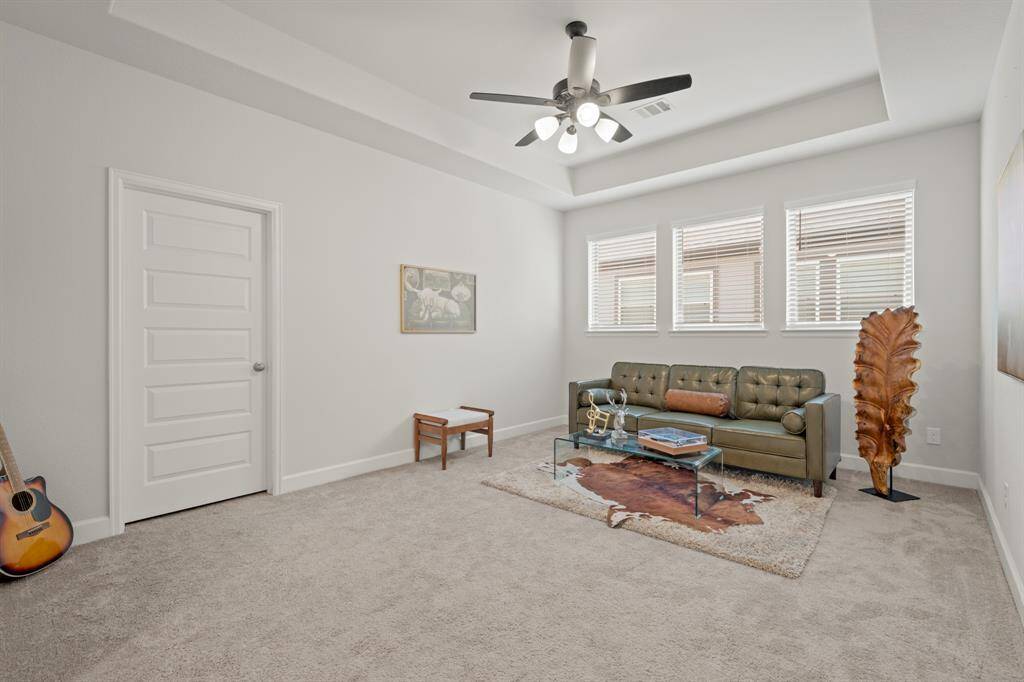 Upstairs you walk into a large game room that's perfect for a pool table, tv's, or a lounging space! It features a trace ceiling, ceiling fan, plush carpet, and three large windows.
