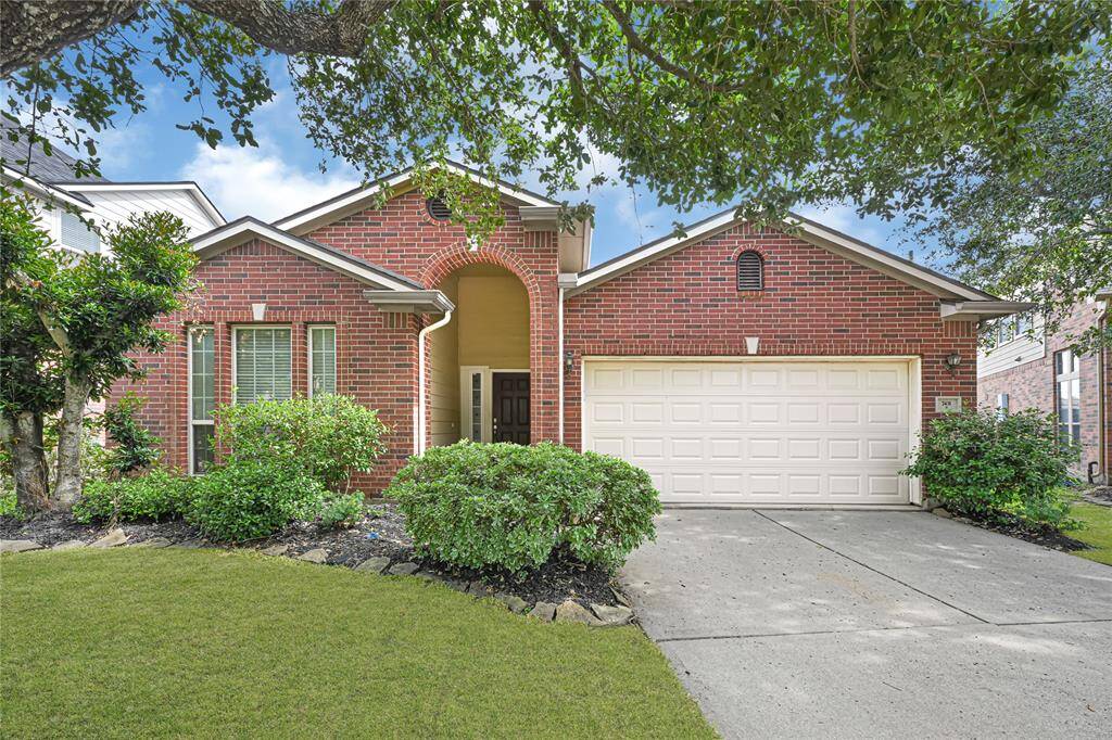 Classic red brick brick elevation with a covered entry and 2-car garage.