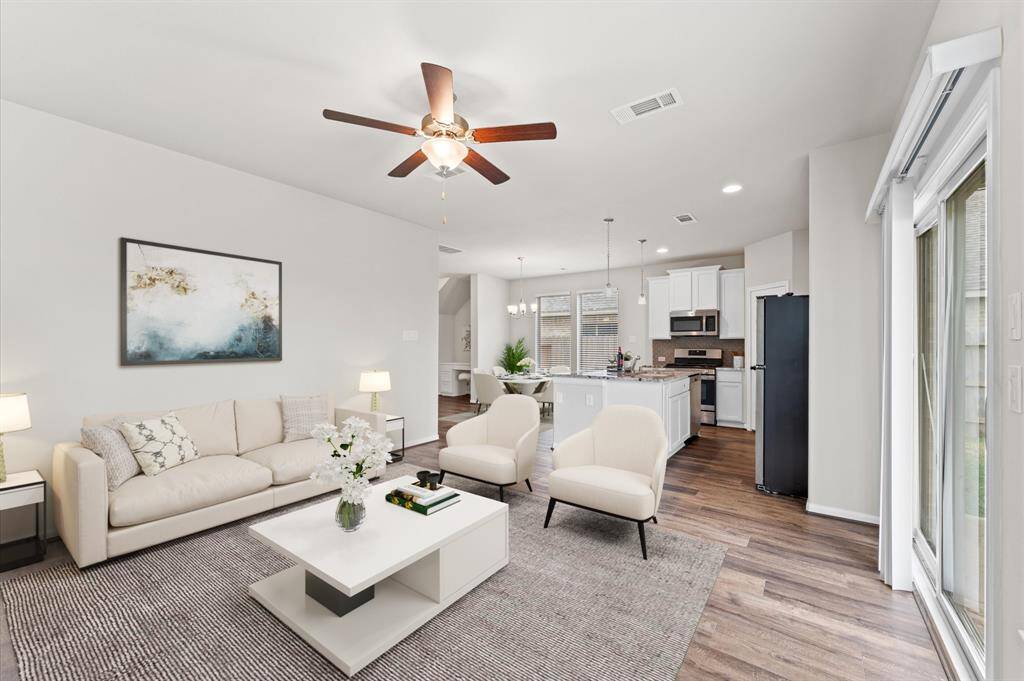 The open layout seamlessly connects to the kitchen and dining area, perfect for entertaining or relaxing with loved ones.