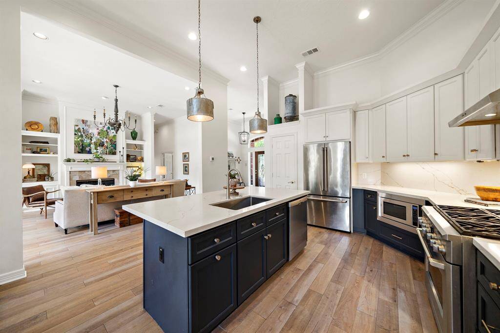 The fabulous kitchen boasts sleek countertops, high-end stainless steel appliances, and ample storage, making it an entertainer’s dream.