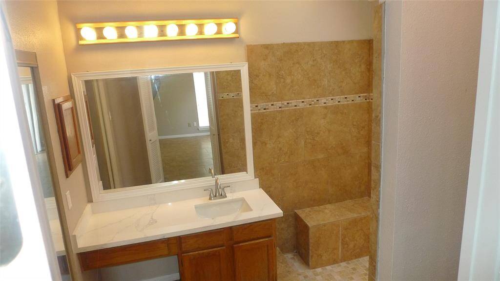Primary Bath with new granite counter tops and sink, walk-in shower with bench seat