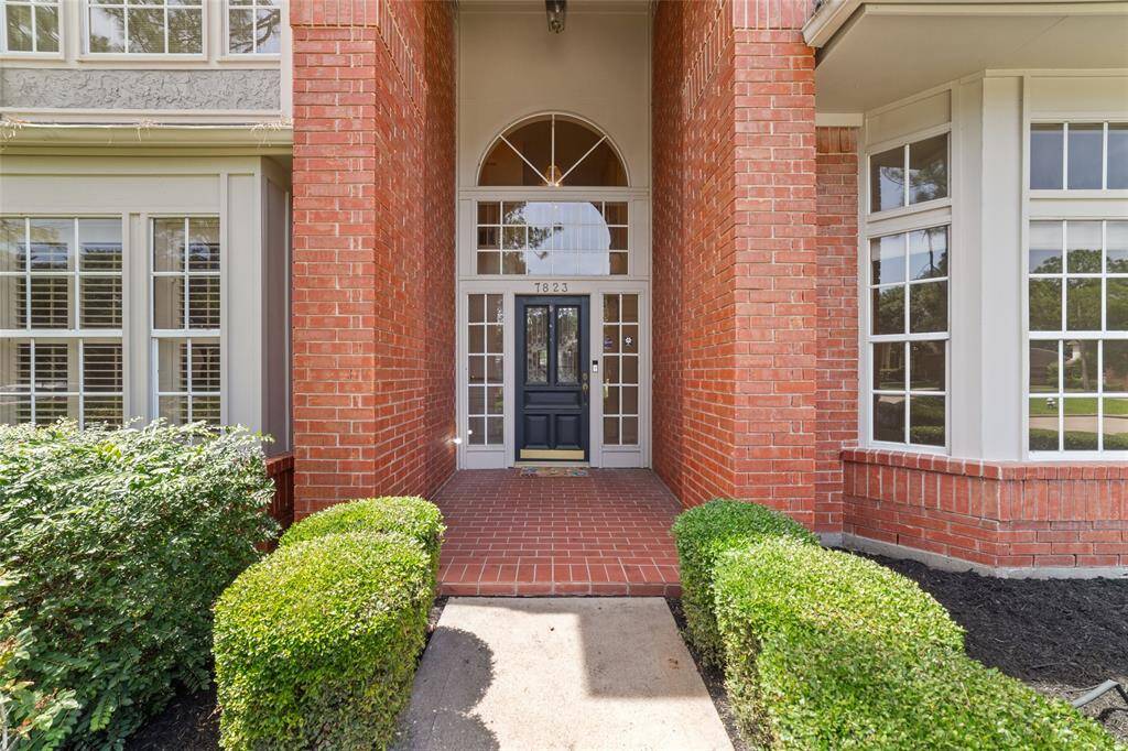 Welcome to this charming brick home, featuring a picturesque walkway and lush, mature landscaping.