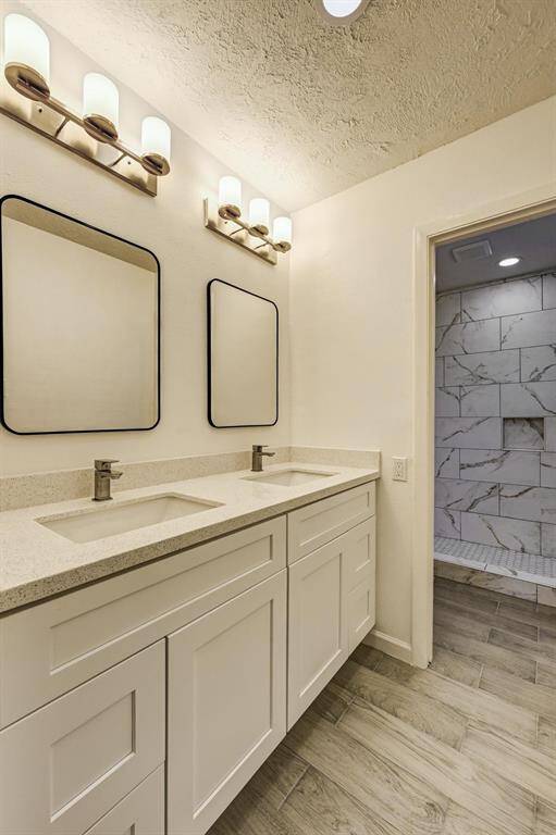 Primary bathroom with double sinks and vanity with custom cabinets