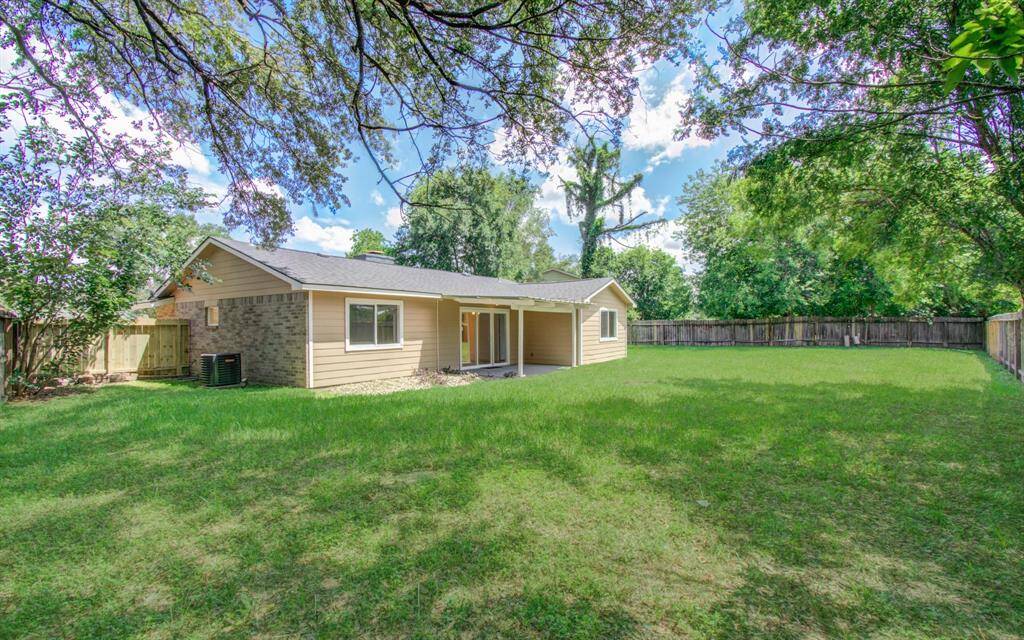 Fully fenced and spacious backyard with a view of the back patio