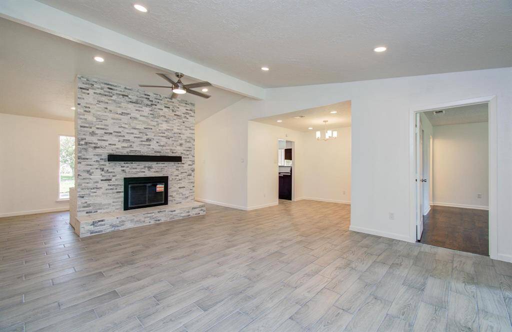 Bright and spacious living room features a modern fireplace