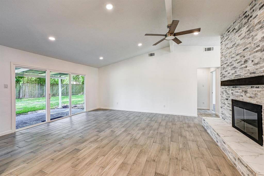 Living room has vaulted ceilings with plenty of recessed lights