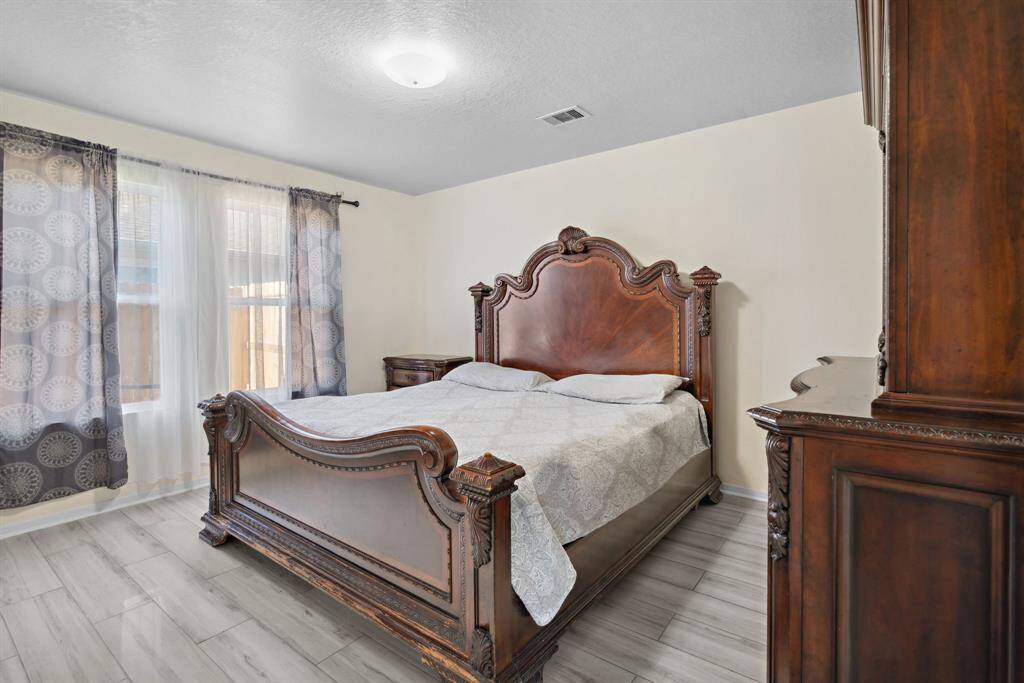 large primary bedroom gives enough space for large bed and furniture