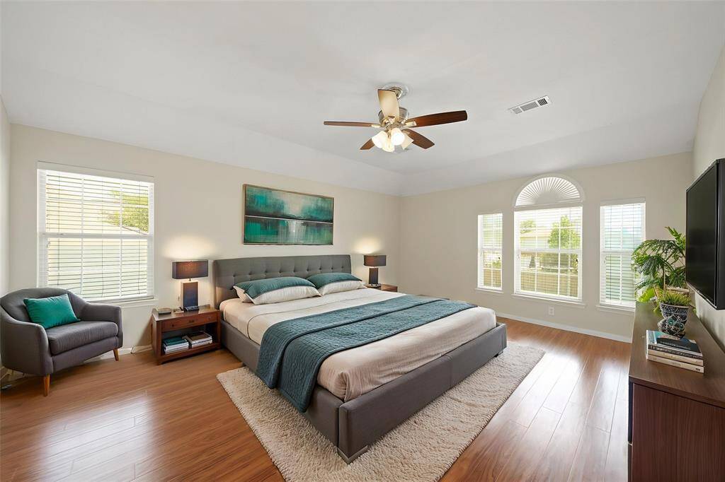 Welcome to your very own retreat! This Primary Bathroom includes a large mirror, granite countertops and backsplash, white cabinetry, and dual sinks.