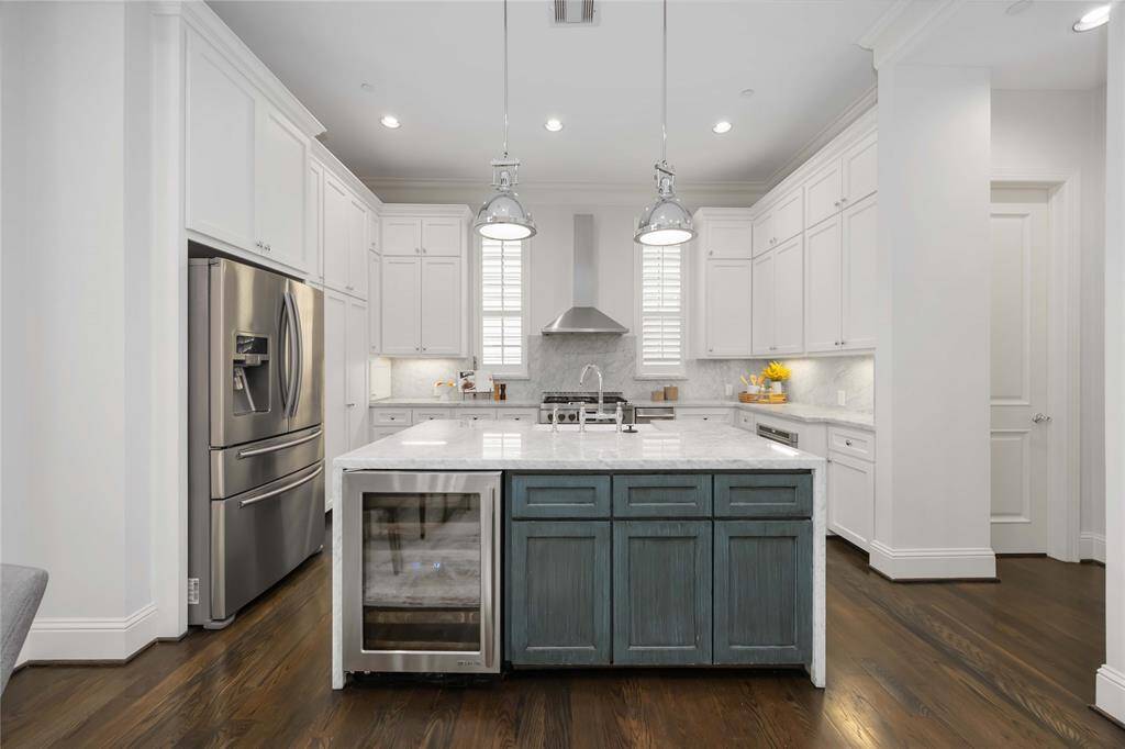 Who doesn't love an island kitchen? This one, topped with Italian Carrara marble, features high-end JennAir appliances, soft-close cabinets, under-cabinet lighting, a built-in beverage cooler, and a 6-burner gas range.