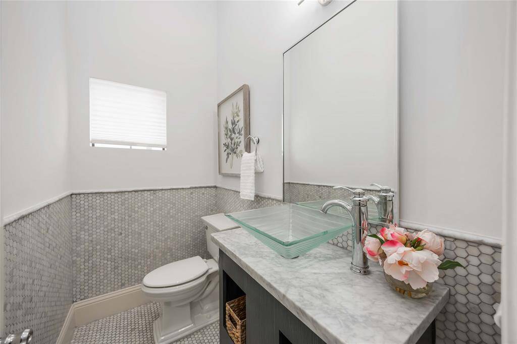 A convenient half bath is located on the 2nd floor. An intricate design includes a stylish glass vessel sink.