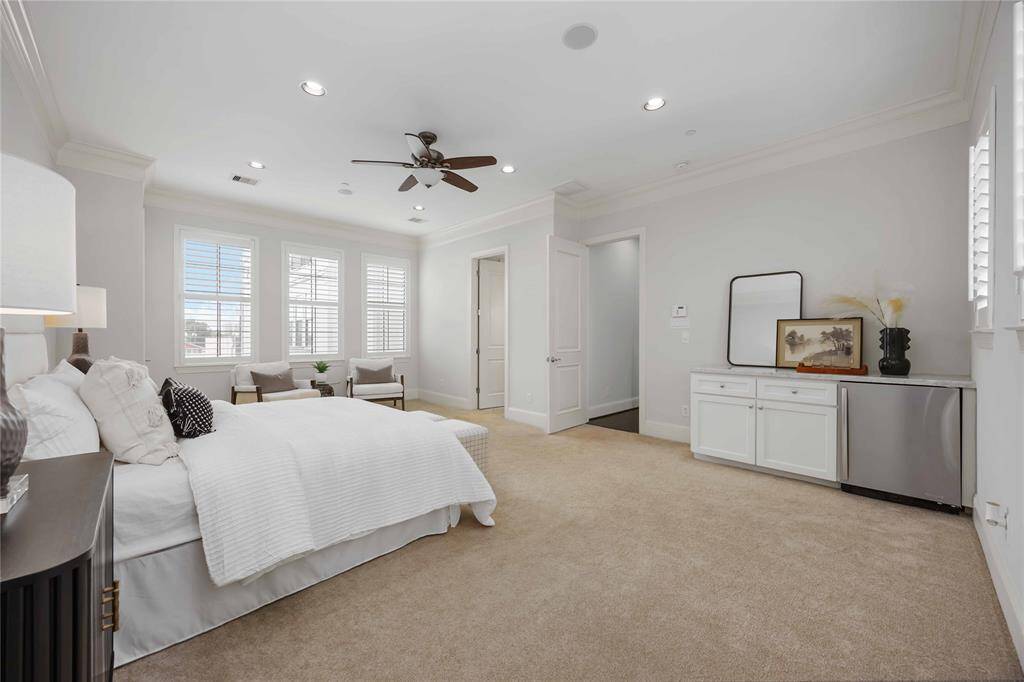 A trio of framed windows allows natural light to fill the room when the plantation shutters are open. This ideal space includes a built-in coffee bar with a beverage cooler!
