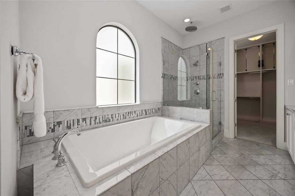 So much thought and design went into the planning of this coveted bath. Look at the detail in the tile surround! The corner shower boasts two shower heads, one being a rain-head shower head.