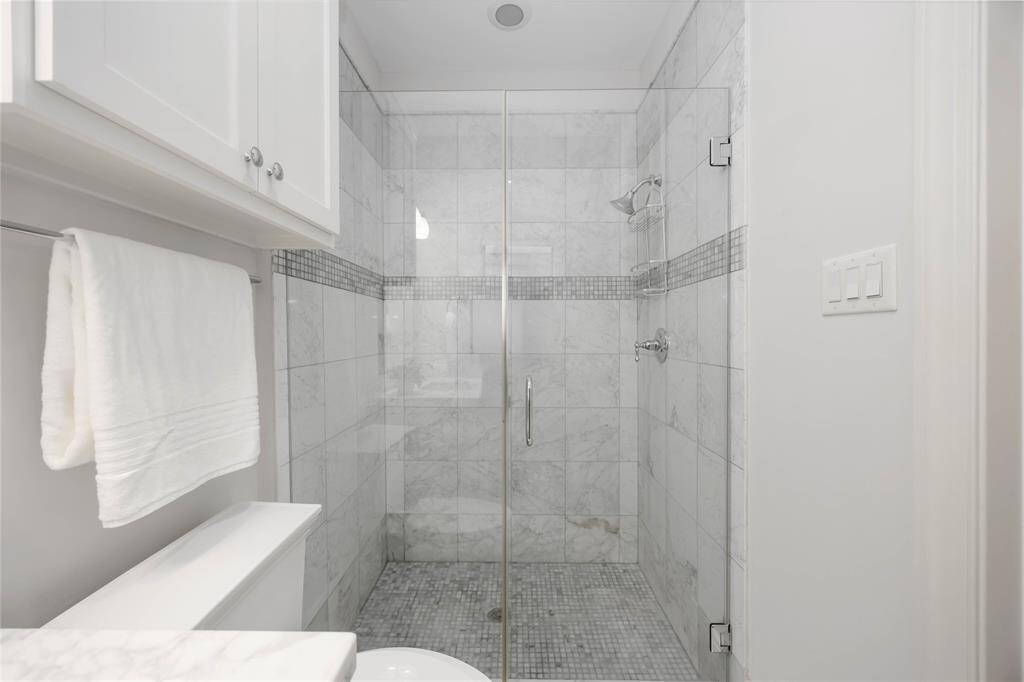 The 1st-floor en suite bath boasts a gorgeous, fully tiled, frameless shower.
