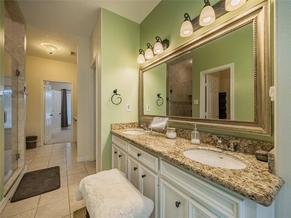 Primary bathroom with dual vanities.